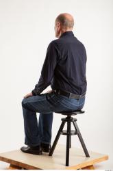 Sitting pose blue deep shirt jeans of Ed